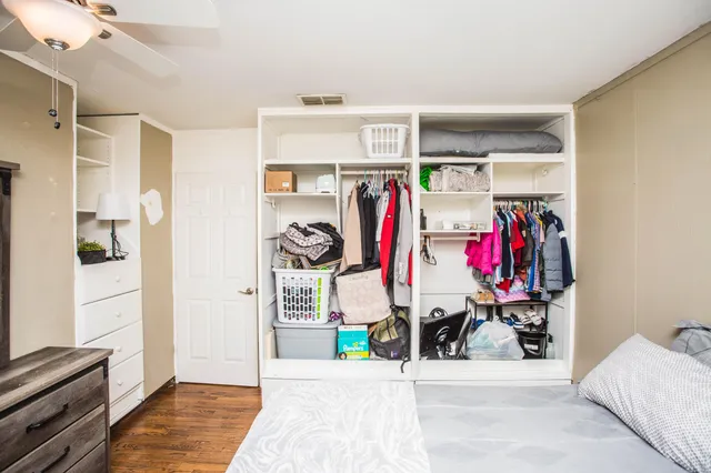 a view of walk in closet with clothes and shoes
