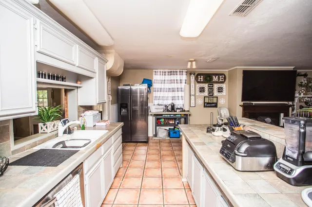 a kitchen with stainless steel appliances kitchen island granite countertop a sink stove and refrigerator