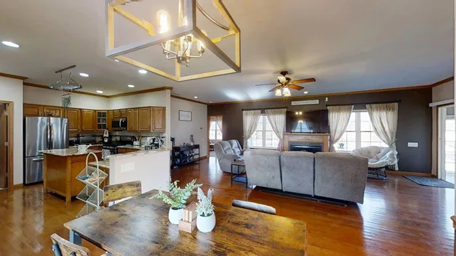 a living room with furniture kitchen view and a wooden floor