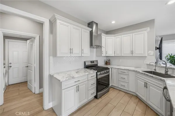 a kitchen with granite countertop white cabinets and white appliances