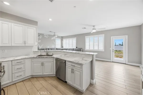 a kitchen with white cabinets and stainless steel appliances