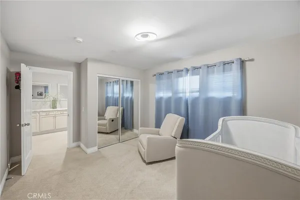 a spacious bedroom with a bed and a chandelier