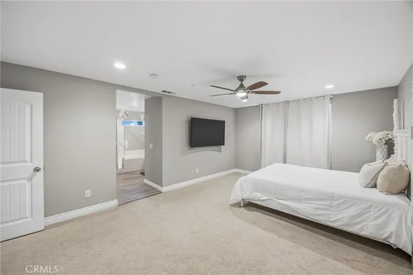 a bedroom with a bed and a ceiling fan
