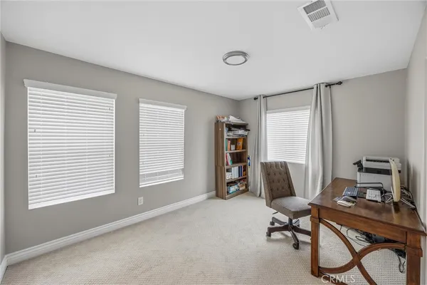 a view of a workspace with furniture and a window