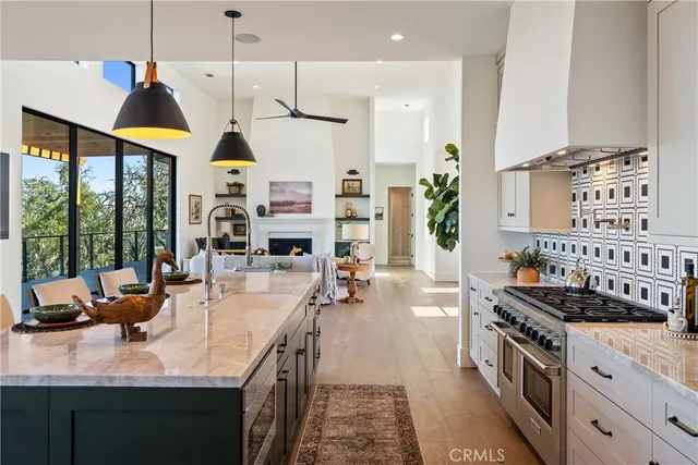 a kitchen with stainless steel appliances granite countertop table chairs and a view of living room