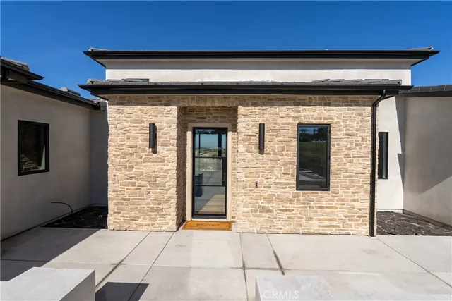 an aerial view of a residential houses with outdoor space and trees