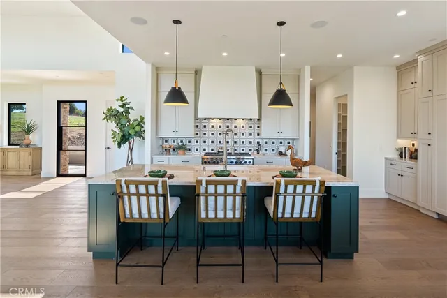 a kitchen with white cabinets and wooden floors