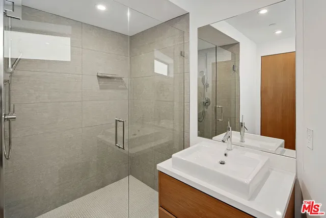 a bathroom with a sink a shower and a mirror