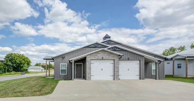 a front view of a house with a garden and garage