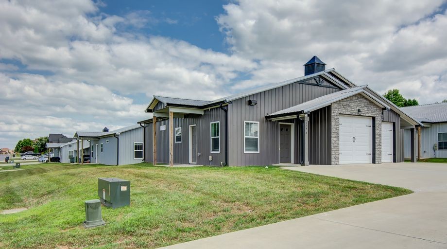 174 Bainbridge Drive, Unit A Clarksville, TN 37043 - Photo 4 of 36 a view of a white house next to a yard with big trees