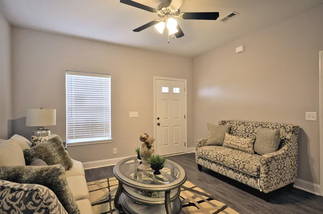 a living room with furniture and a wooden floor