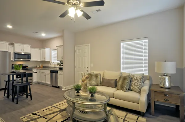 a living room with furniture and kitchen view