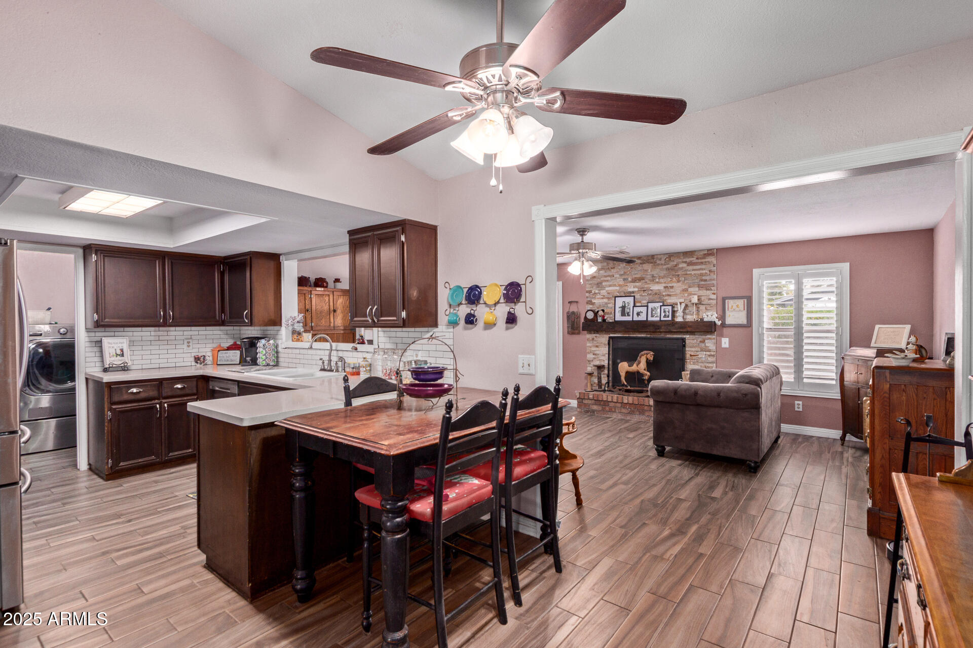 317 East Harwell Road Gilbert, AZ 85234 - Photo 7 of 29 a open dining room with stainless steel appliances kitchen island granite countertop furniture wooden floor and a fireplace