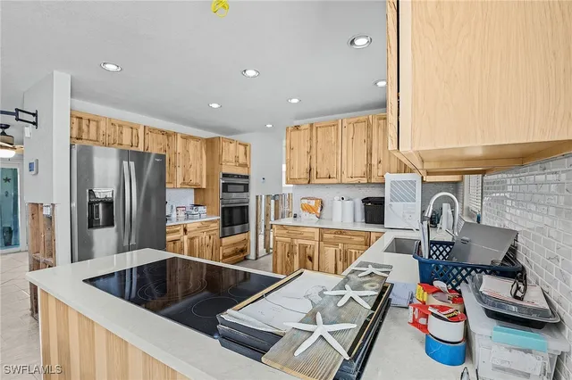 a kitchen with stainless steel appliances a refrigerator sink and cabinets