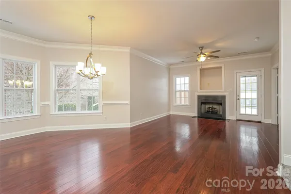 a view of empty room with wooden floor and fireplace