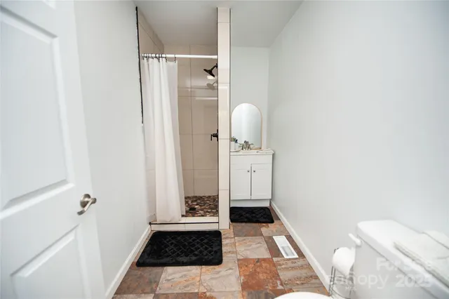 a bathroom with a toilet and a shower