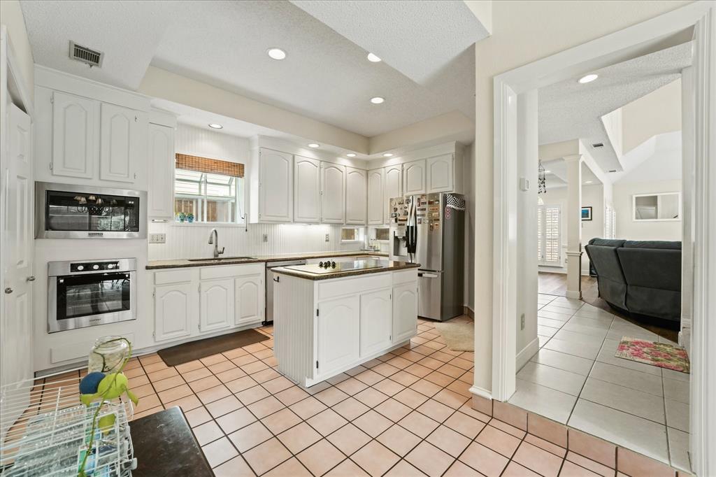 9420 Blue Jay Way Irving, TX 75063 - Photo 11 of 27 a kitchen with a sink cabinets and stainless steel appliances