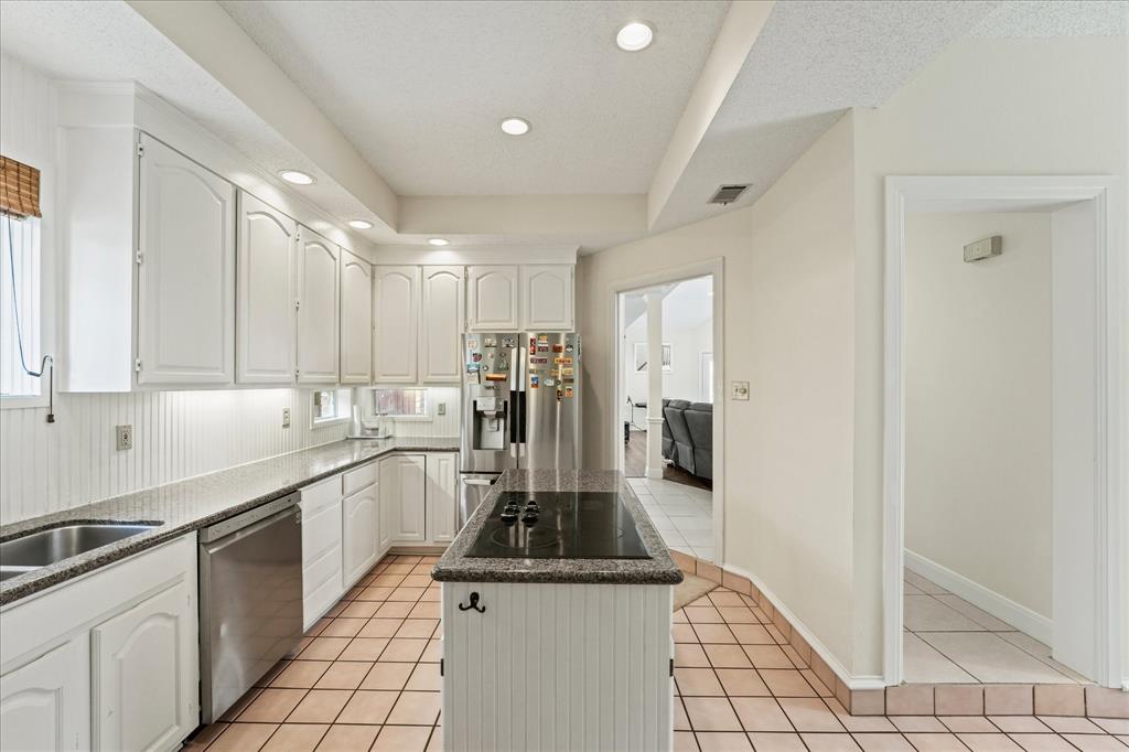 9420 Blue Jay Way Irving, TX 75063 - Photo 12 of 27 a kitchen with stainless steel appliances granite countertop a stove a sink and a refrigerator