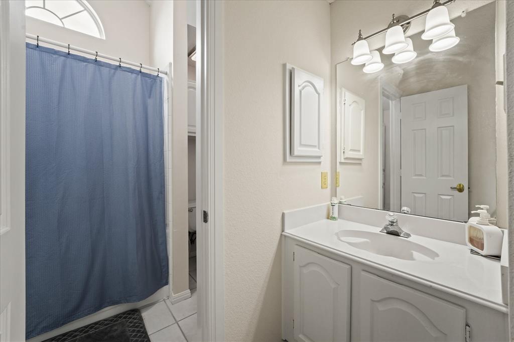 9420 Blue Jay Way Irving, TX 75063 - Photo 17 of 27 a bathroom with a double vanity sink and mirror