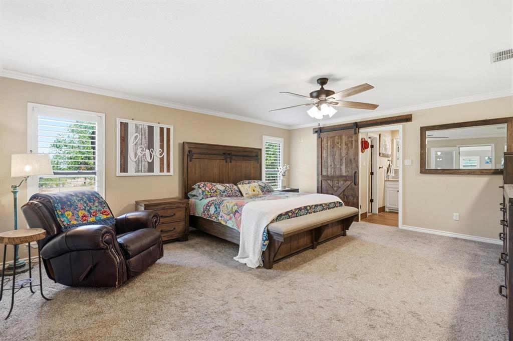 432 Clark Road Abilene, TX 79602 - Photo 12 of 40 a spacious bedroom with a bed a couch and a ceiling fan