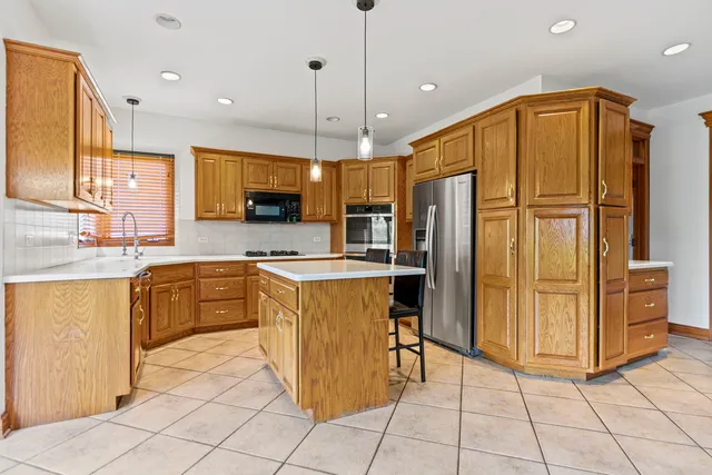 a kitchen with stainless steel appliances granite countertop a refrigerator and a stove top oven
