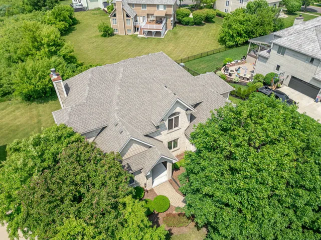 an aerial view of a house with a garden and lake view