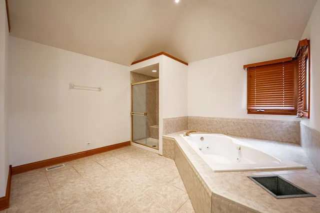 a bathroom with a granite countertop tub and a sink
