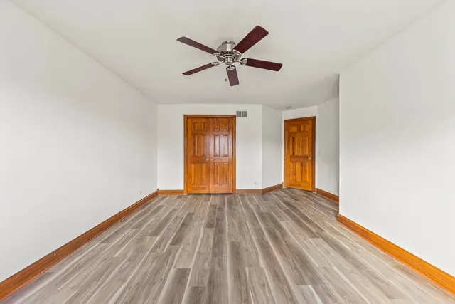 a view of room with wooden floor and ceiling fan