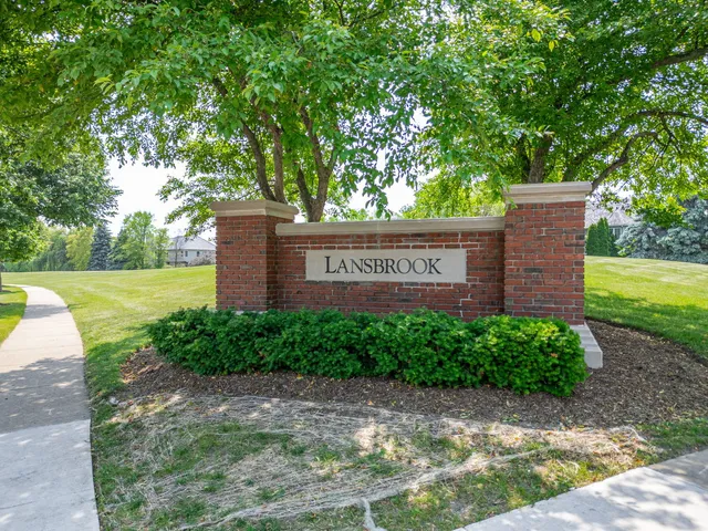 a sign that is sitting in front of a tree