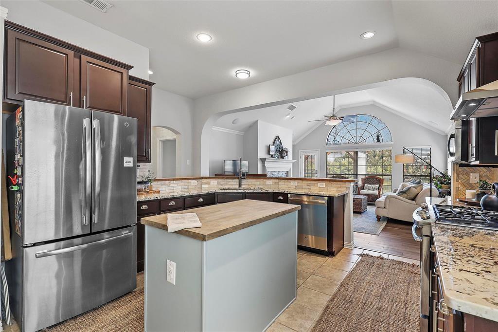 7067 Nantucket Way Grand Prairie, TX 75054 - Photo 11 of 40 a kitchen with a refrigerator a sink and a stove top oven