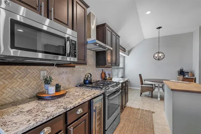 a kitchen with stainless steel appliances granite countertop a stove a sink and a microwave