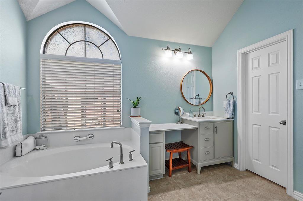 7067 Nantucket Way Grand Prairie, TX 75054 - Photo 24 of 40 a bathroom with a sink a mirror a bathtub and a window