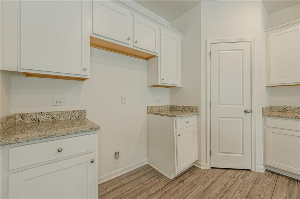628 Isom Walk Suwanee, GA 30024 - Photo 11 of 39 a view of cabinets and wooden floor