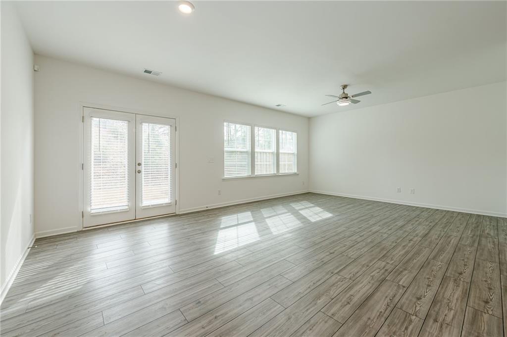 628 Isom Walk Suwanee, GA 30024 - Photo 15 of 39 an empty room with wooden floor and windows