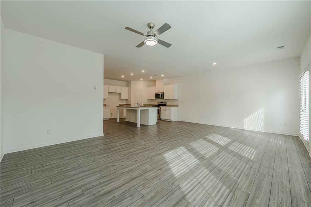 628 Isom Walk Suwanee, GA 30024 - Photo 18 of 39 a view of a workspace with wooden floor and a ceiling fan