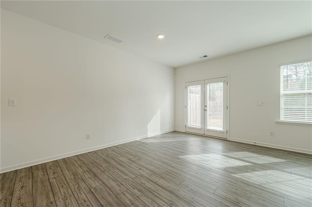 628 Isom Walk Suwanee, GA 30024 - Photo 19 of 39 a view of an empty room with wooden floor and window