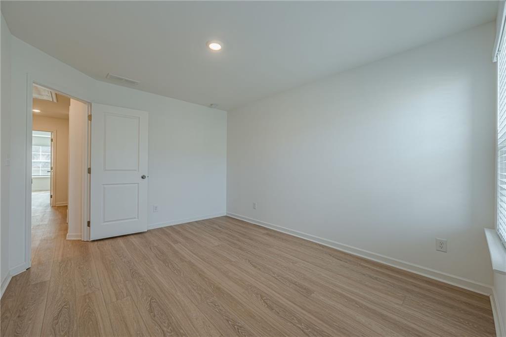 628 Isom Walk Suwanee, GA 30024 - Photo 22 of 39 an empty room with wooden floor