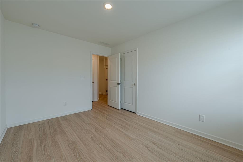 628 Isom Walk Suwanee, GA 30024 - Photo 25 of 39 a view of an empty room with wooden floor