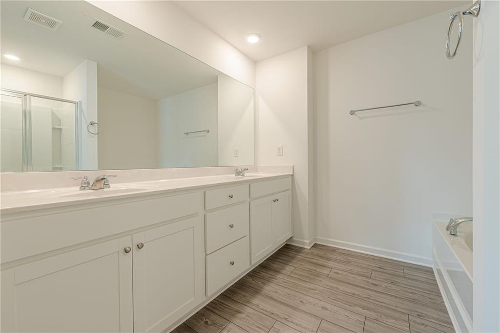 628 Isom Walk Suwanee, GA 30024 - Photo 30 of 39 a bathroom with a double vanity sink and mirror