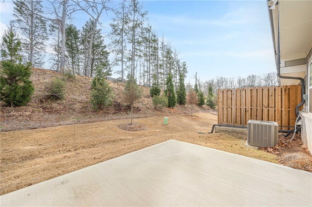 628 Isom Walk Suwanee, GA 30024 - Photo 34 of 39 a backyard of a house with large trees and outdoor seating