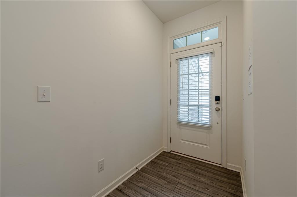 628 Isom Walk Suwanee, GA 30024 - Photo 6 of 39 a view of an empty room with wooden floor and a window