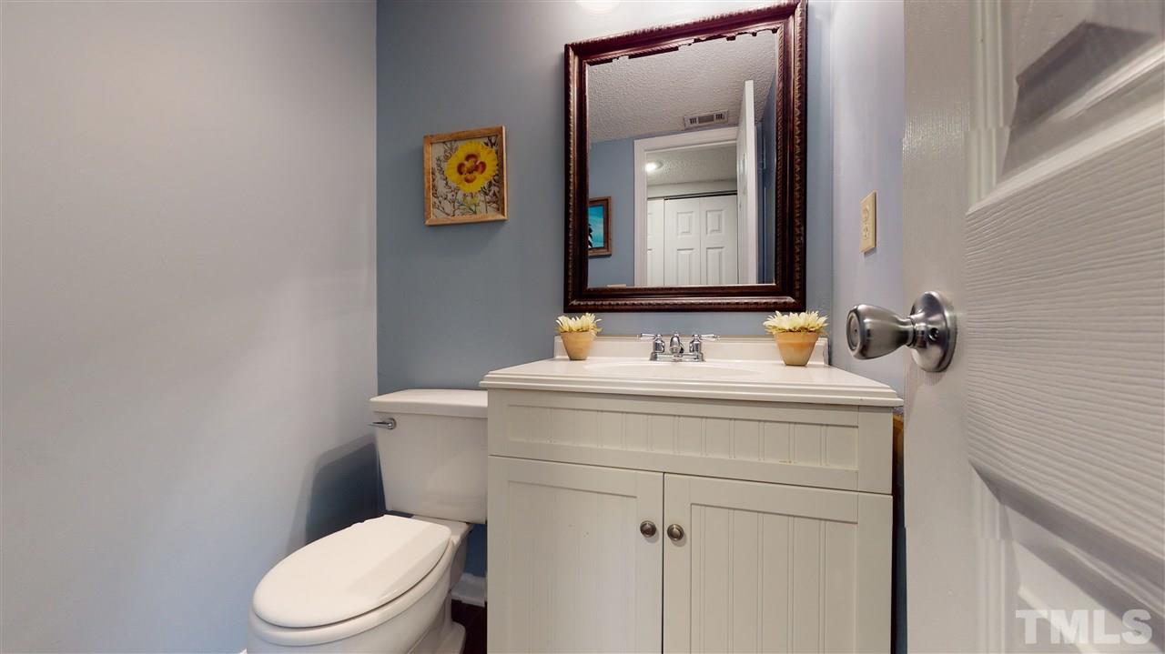 7744 Falcon Rest Circle Raleigh, NC 27615 - Photo 11 of 22 a bathroom with a toilet sink vanity and mirror
