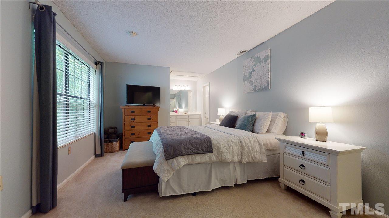 7744 Falcon Rest Circle Raleigh, NC 27615 - Photo 13 of 22 a bedroom with a bed and a tv