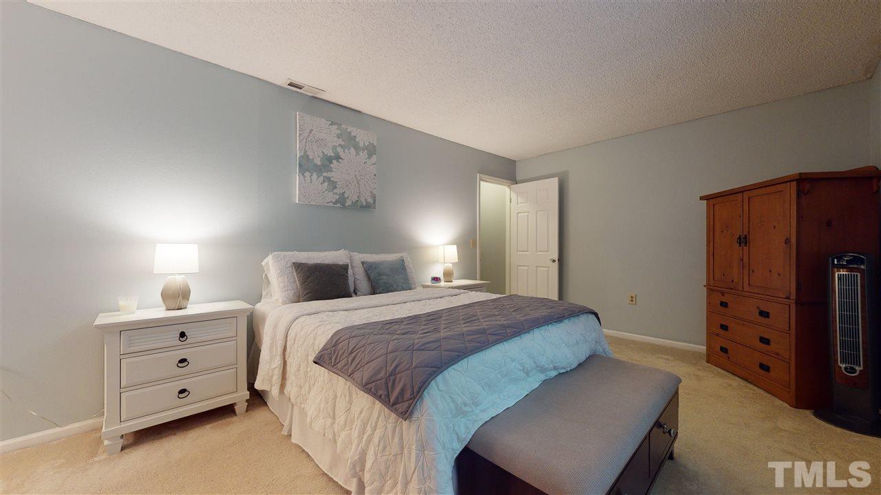 7744 Falcon Rest Circle Raleigh, NC 27615 - Photo 14 of 22 a bedroom with a bed and a dresser