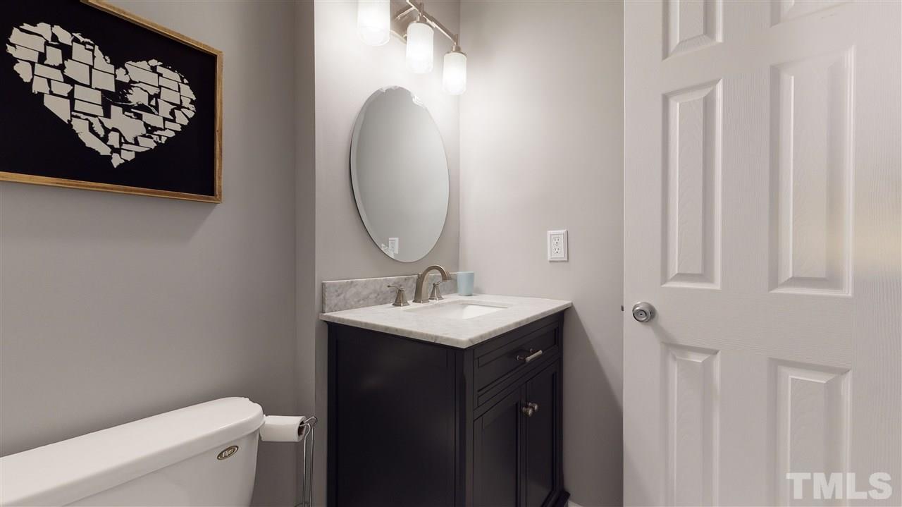 7744 Falcon Rest Circle Raleigh, NC 27615 - Photo 20 of 22 a bathroom with a granite countertop sink and a mirror