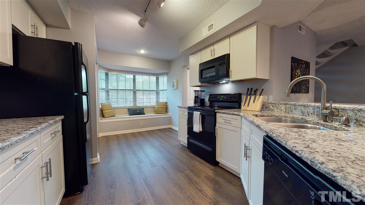 7744 Falcon Rest Circle Raleigh, NC 27615 - Photo 21 of 22 a kitchen with granite countertop a sink stove and refrigerator