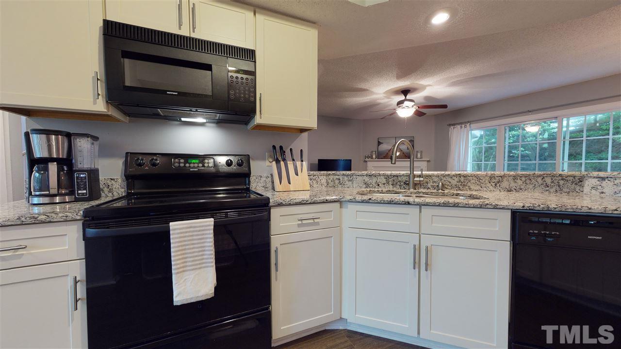 7744 Falcon Rest Circle Raleigh, NC 27615 - Photo 22 of 22 a kitchen with stainless steel appliances granite countertop a stove and a microwave