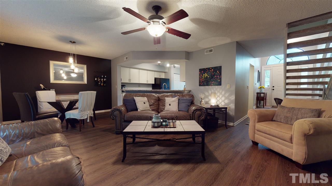 7744 Falcon Rest Circle Raleigh, NC 27615 - Photo 8 of 22 a living room with furniture a fireplace and a flat screen tv