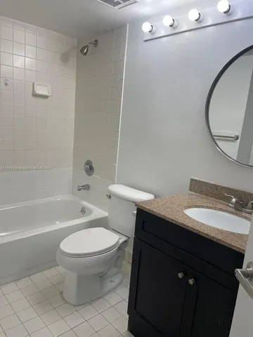 a bathroom with a toilet a sink a mirror and a bathtub