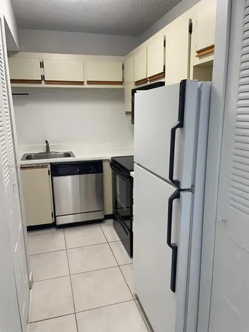 a kitchen with a refrigerator and cabinets